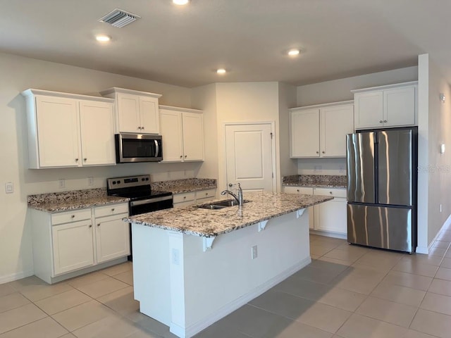 7937 Wheat Stone Dr, Zephyrhills, FL 33540 - kitchen with appliances with stainless steel finishes, a sink, white cabinetry, light stone counters, and recessed lighting