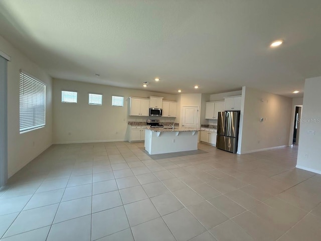 7937 Wheat Stone Dr, Zephyrhills, FL 33540 - kitchen with appliances with stainless steel finishes, open floor plan, recessed lighting, light tile patterned floors, and an island with sink
