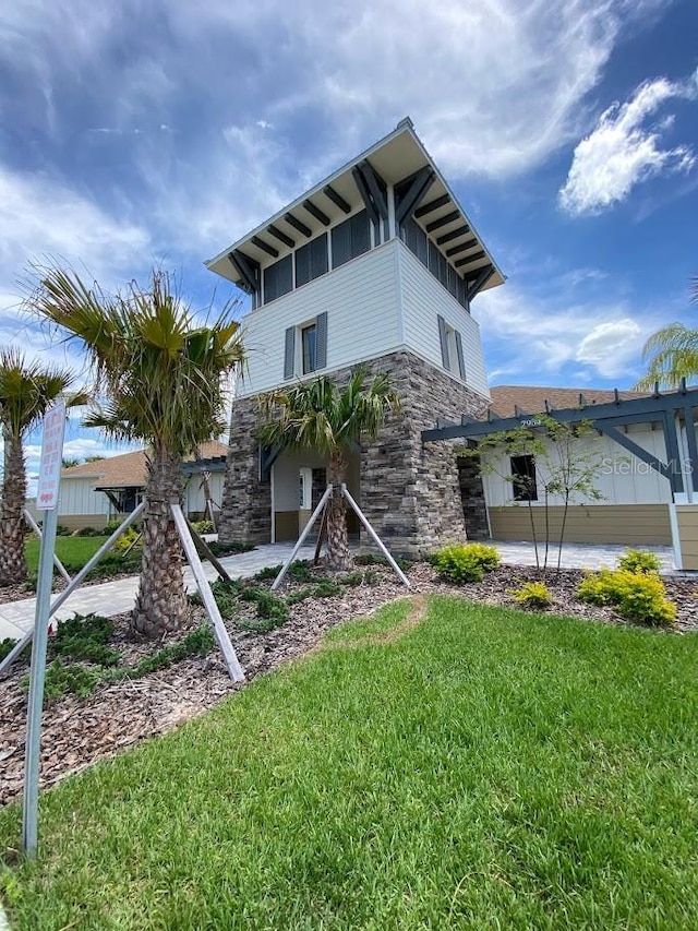 7937 Wheat Stone Dr, Zephyrhills, FL 33540 - view of side of property with stone siding, a lawn, and board and batten siding