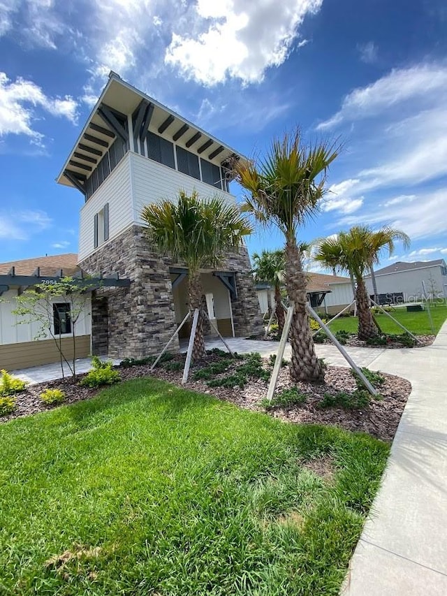 7937 Wheat Stone Dr, Zephyrhills, FL 33540 - view of side of property featuring stone siding and a lawn