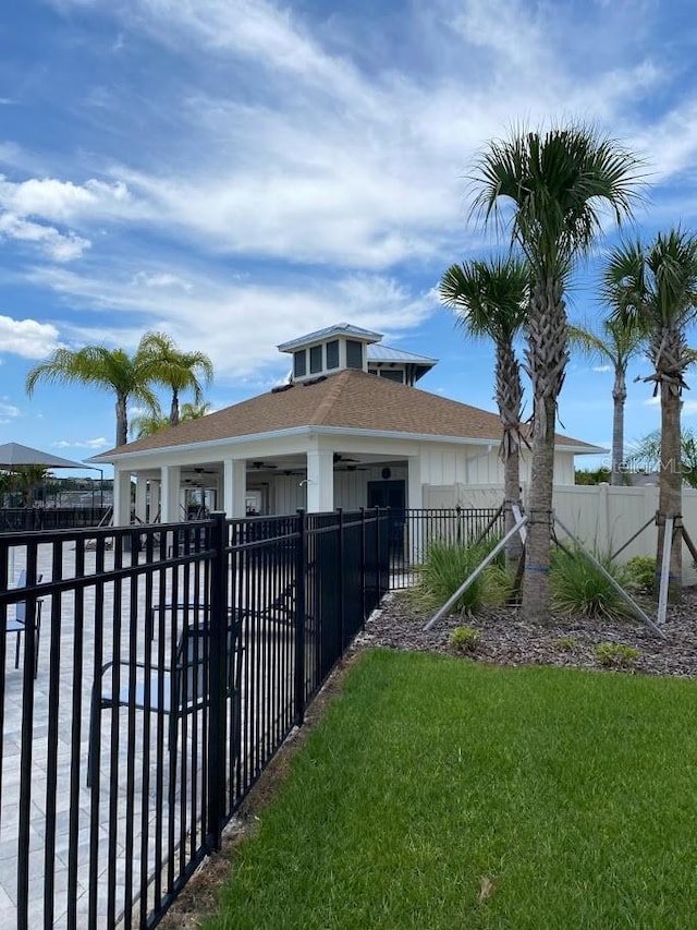 7937 Wheat Stone Dr, Zephyrhills, FL 33540 - view of front of house with a ceiling fan, a fenced front yard, and roof with shingles