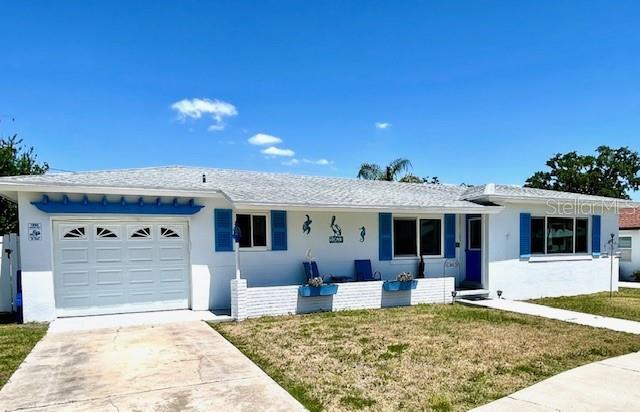 ranch-style house with a garage, driveway, covered porch, a front yard, and stucco siding