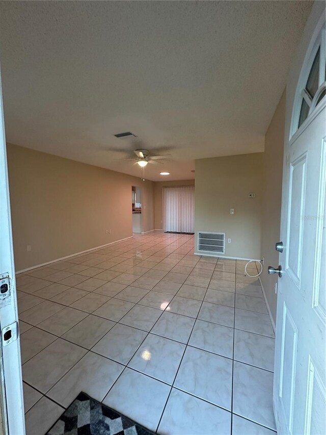 7601 Como Dr, New Port Richey, FL 34655 - empty room with baseboards, a ceiling fan, visible vents, and light tile patterned floors