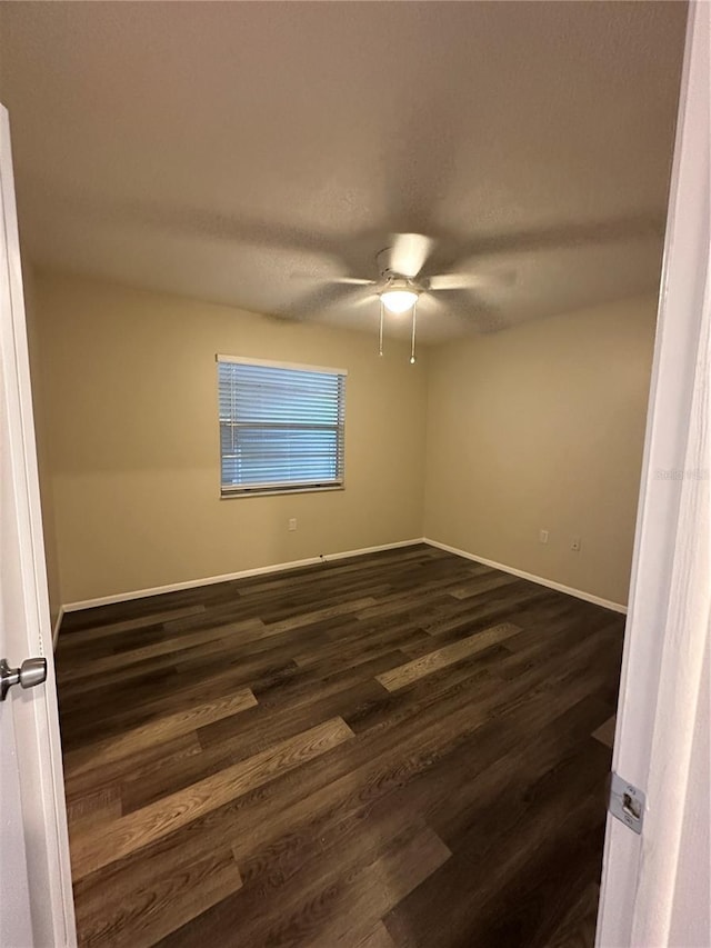 7601 Como Dr, New Port Richey, FL 34655 - spare room featuring baseboards, a ceiling fan, and dark wood-style floors