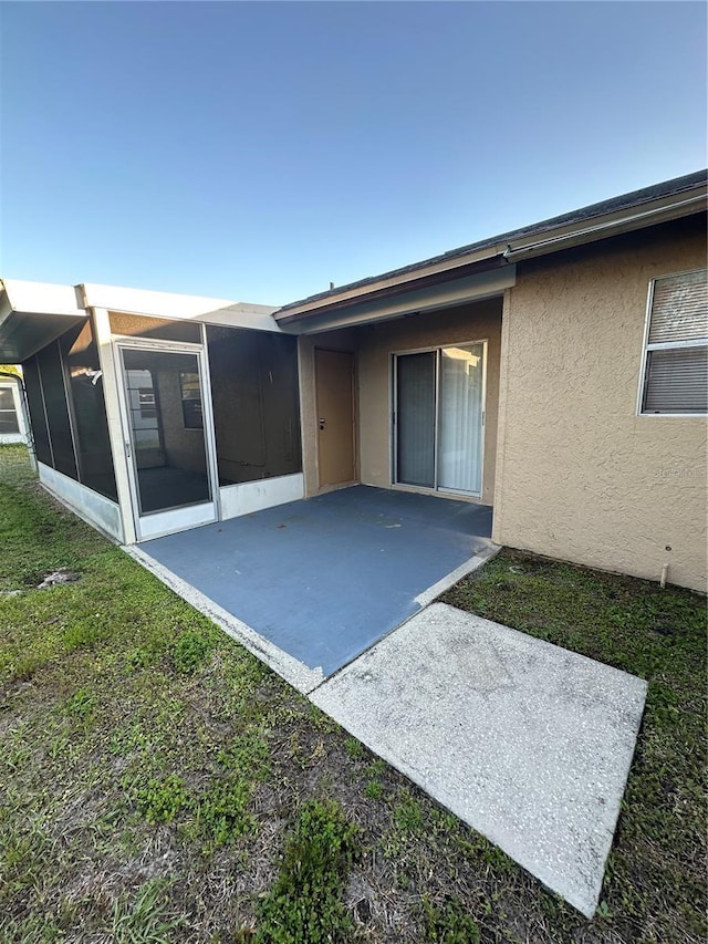 7601 Como Dr, New Port Richey, FL 34655 - rear view of property featuring stucco siding, a sunroom, and a patio
