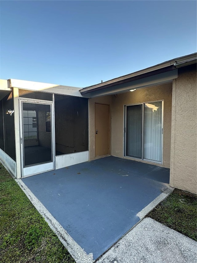 7601 Como Dr, New Port Richey, FL 34655 - rear view of house featuring stucco siding, a sunroom, and a patio