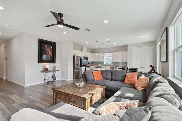 living area with a ceiling fan, baseboards, recessed lighting, dark wood-type flooring, and visible vents