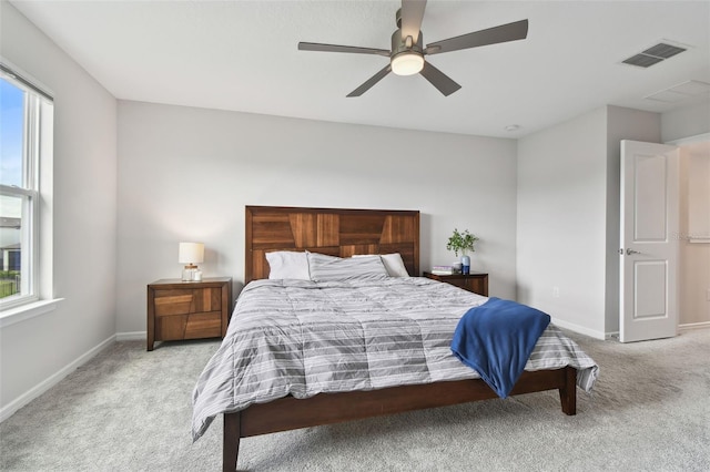 bedroom featuring multiple windows, light colored carpet, and visible vents