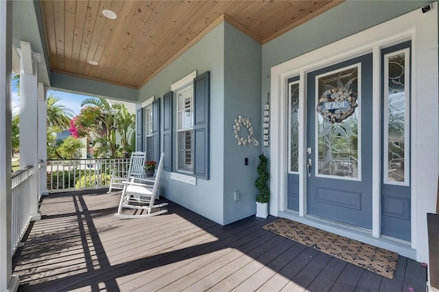 entrance to property with a porch and stucco siding