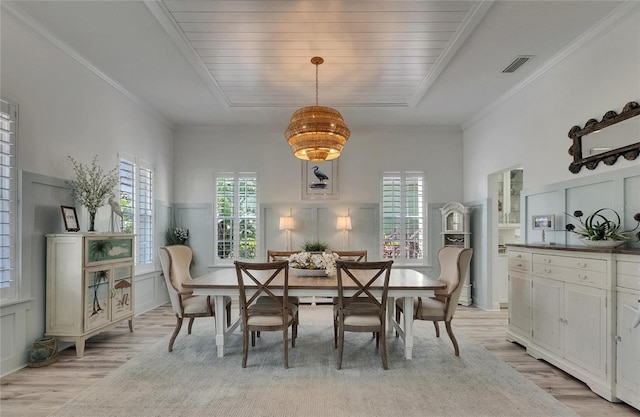 dining room with a decorative wall, light wood-type flooring, visible vents, and plenty of natural light