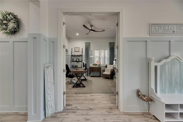 hall with light wood-type flooring and crown molding