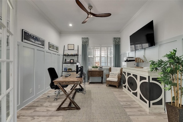 office space with light wood finished floors, a ceiling fan, ornamental molding, and a decorative wall