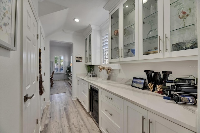 bar featuring vaulted ceiling, beverage cooler, light wood-style floors, ornamental molding, and recessed lighting