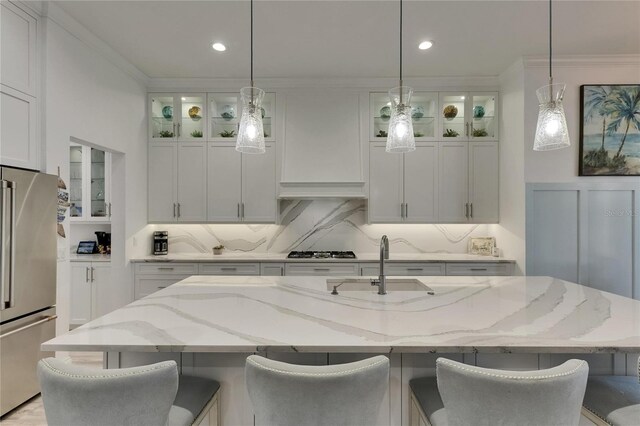 kitchen with stainless steel appliances, a sink, white cabinetry, and ornamental molding
