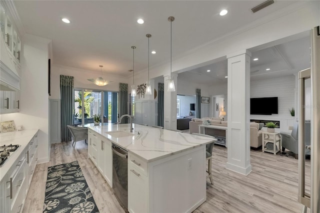 kitchen with white cabinets, stainless steel appliances, a sink, a large island, and visible vents