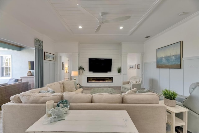 living room with recessed lighting, a wainscoted wall, visible vents, a glass covered fireplace, and ceiling fan