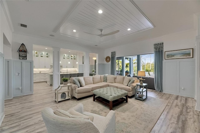 living area with light wood finished floors, visible vents, recessed lighting, a ceiling fan, and a decorative wall