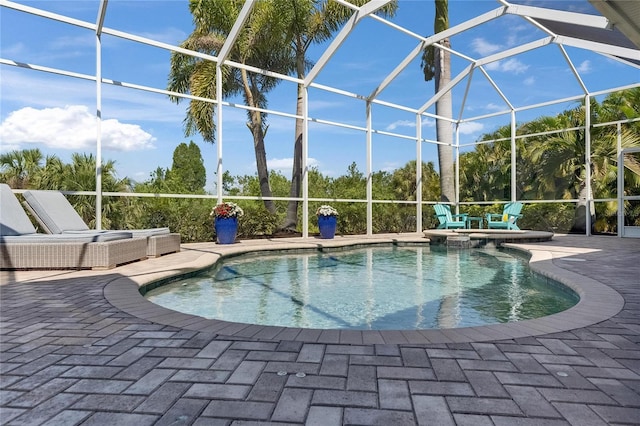view of swimming pool featuring a patio area, a lanai, and a pool with connected hot tub