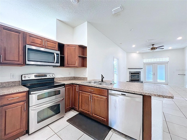 11535 Wellman Dr, Riverview, FL 33578 - kitchen featuring open shelves, light tile patterned flooring, a peninsula, appliances with stainless steel finishes, and visible vents