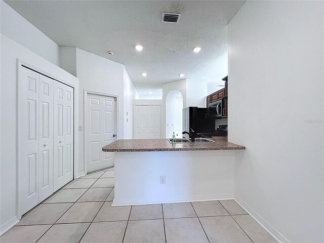 11535 Wellman Dr, Riverview, FL 33578 - kitchen featuring a peninsula, a sink, stainless steel microwave, light tile patterned flooring, and visible vents