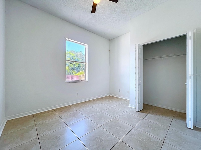 11535 Wellman Dr, Riverview, FL 33578 - unfurnished bedroom featuring a textured ceiling, baseboards, a ceiling fan, tile patterned flooring, and a closet