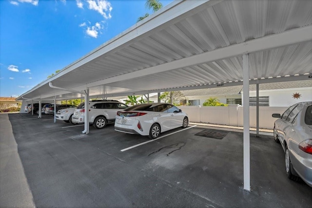covered parking lot featuring fence
