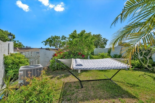 view of yard featuring central AC and fence