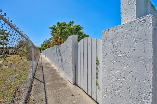 view of side of home with a gate and fence