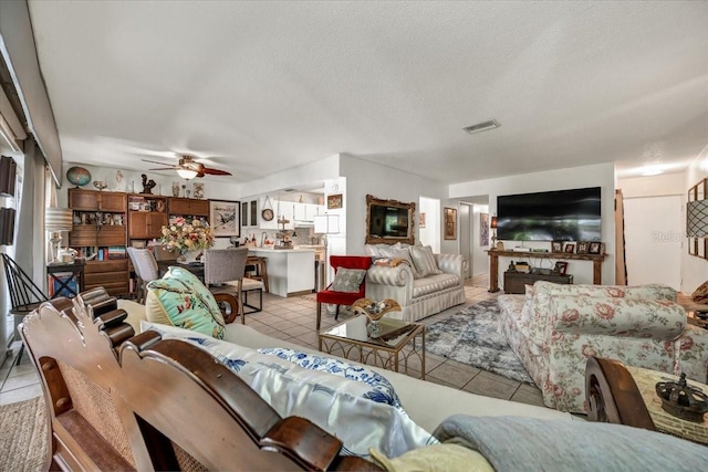 living area with visible vents, ceiling fan, and light tile patterned flooring