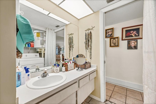 bathroom with washer / dryer, baseboards, tile patterned flooring, and vanity