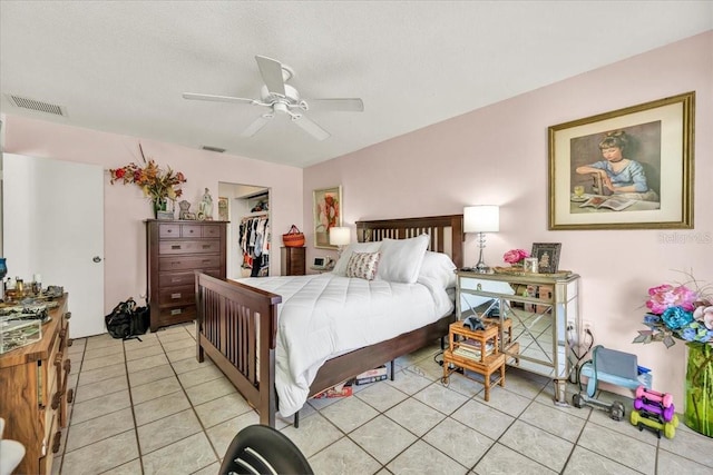 bedroom featuring light tile patterned flooring, a closet, visible vents, and ceiling fan