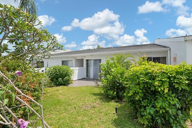 1655 S Highland Ave Unit C155, Largo, FL 33756 - back of house featuring stucco siding and a lawn