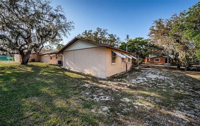 618 July Dr, Tarpon Springs, FL 34689 - view of side of property featuring a lawn and stucco siding