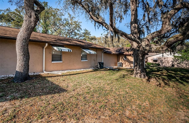 618 July Dr, Tarpon Springs, FL 34689 - rear view of property with a lawn and stucco siding