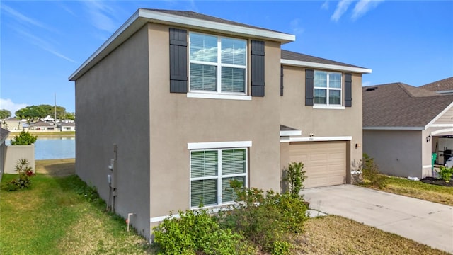 view of front facade featuring an attached garage, concrete driveway, a front lawn, and stucco siding
