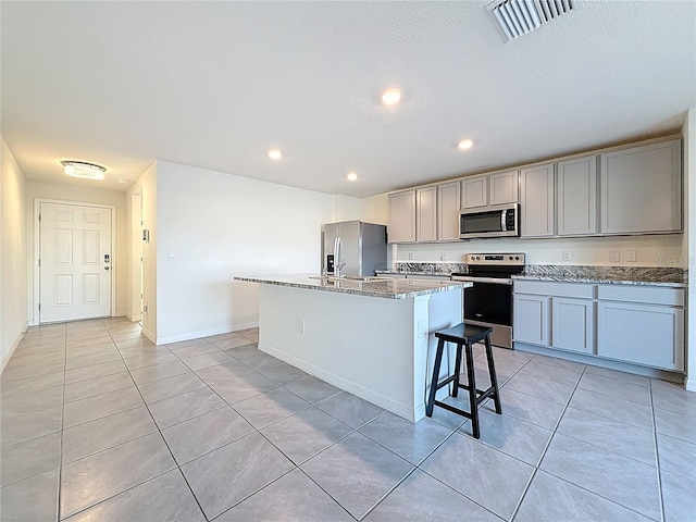 kitchen with light tile patterned flooring, visible vents, appliances with stainless steel finishes, and gray cabinets
