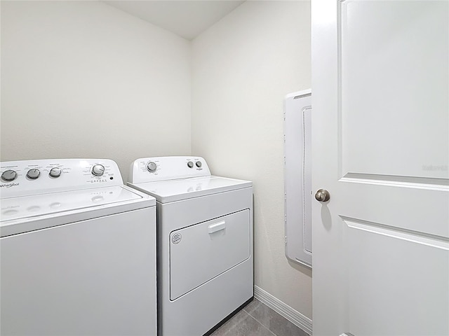 laundry room with separate washer and dryer, baseboards, laundry area, and dark tile patterned flooring