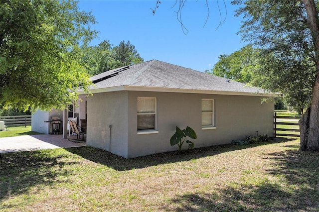 view of property exterior featuring fence, a patio, a shingled roof, and stucco siding