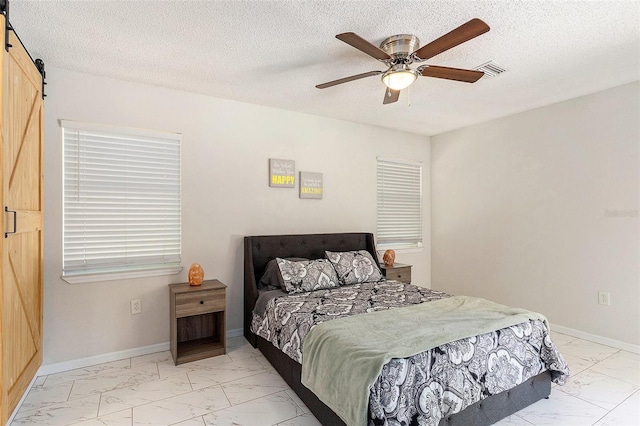 bedroom with visible vents, marble finish floor, ceiling fan, and a barn door