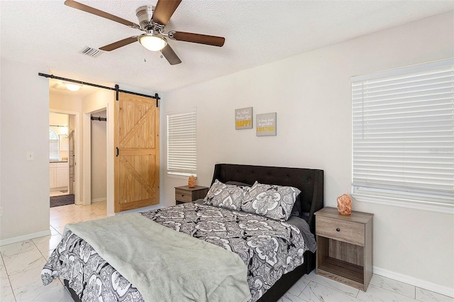 bedroom featuring baseboards, visible vents, marble finish floor, and a barn door