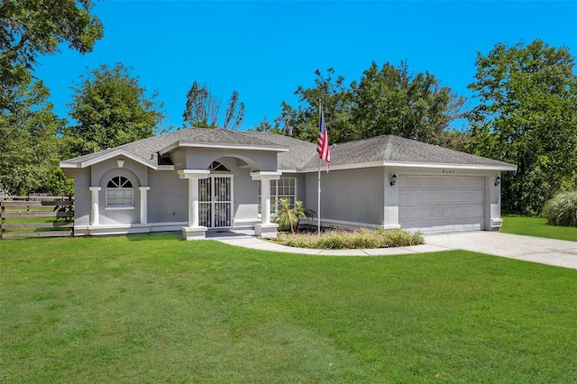 view of front of house with concrete driveway, a front lawn, an attached garage, stucco siding, and roof with shingles