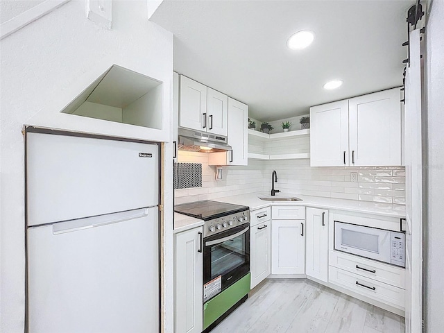1600 Pasadena Dr, Dunedin, FL 34698 - kitchen featuring open shelves, white appliances, white cabinetry, under cabinet range hood, and recessed lighting