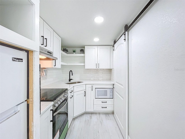 1600 Pasadena Dr, Dunedin, FL 34698 - kitchen with a sink, freestanding refrigerator, white microwave, stainless steel range with electric stovetop, and open shelves