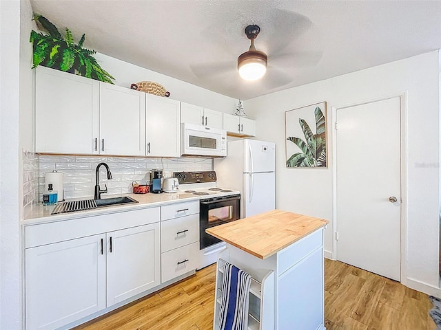 1600 Pasadena Dr, Dunedin, FL 34698 - kitchen featuring white appliances, a sink, decorative backsplash, and light wood-type flooring