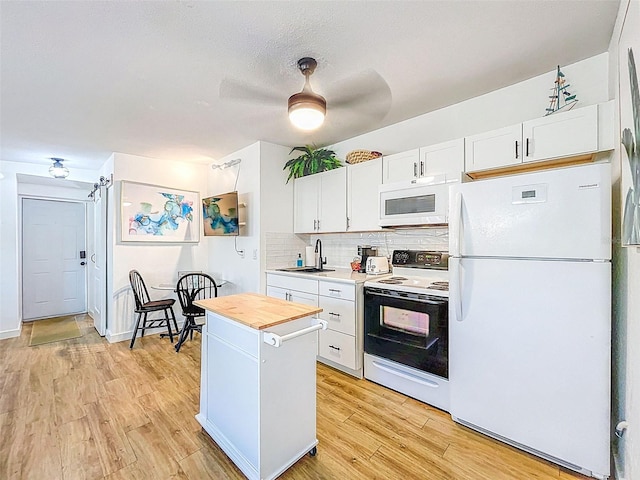 1600 Pasadena Dr, Dunedin, FL 34698 - kitchen with white appliances, a sink, white cabinetry, tasteful backsplash, and light wood-style floors