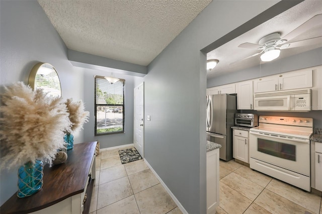 319 Kelsey Way, Sun City Center, FL 33573 - kitchen featuring white cabinets, a textured ceiling, light tile patterned floors, and white appliances