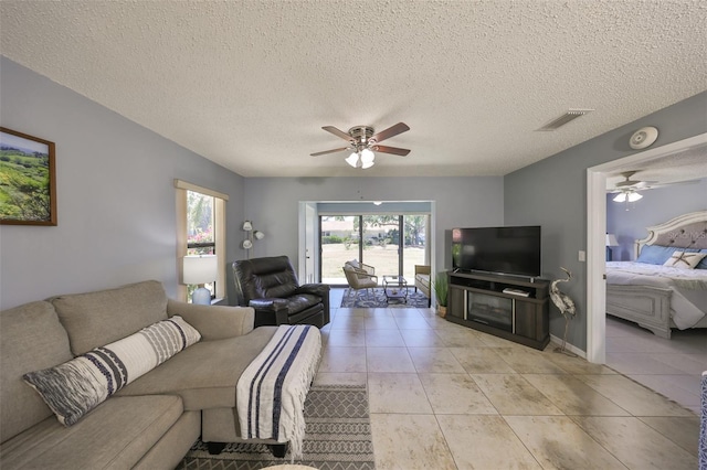 319 Kelsey Way, Sun City Center, FL 33573 - living room with light tile patterned flooring, a textured ceiling, visible vents, and ceiling fan