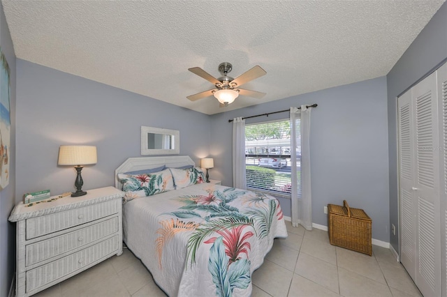 319 Kelsey Way, Sun City Center, FL 33573 - bedroom featuring a ceiling fan, light tile patterned floors, a closet, baseboards, and a textured ceiling