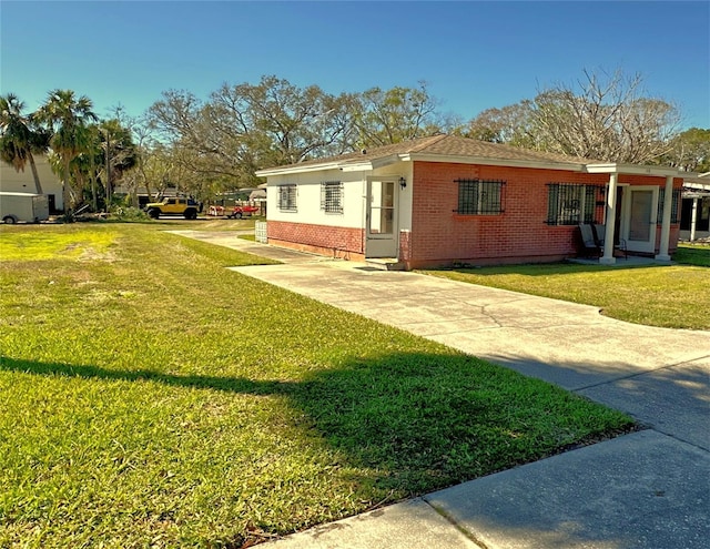 318 Banana St, Tarpon Springs, FL 34689 - view of side of property featuring brick siding and a lawn