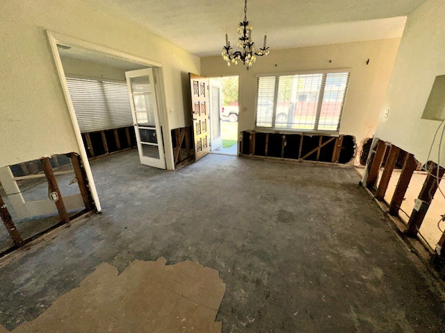 318 Banana St, Tarpon Springs, FL 34689 - unfurnished dining area featuring unfinished concrete flooring and a notable chandelier